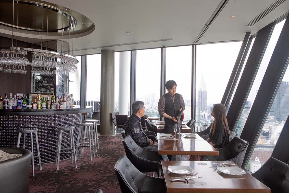 コンフォリア新宿イーストサイドタワー最上階のレストランにて、ワインを楽しむご夫婦